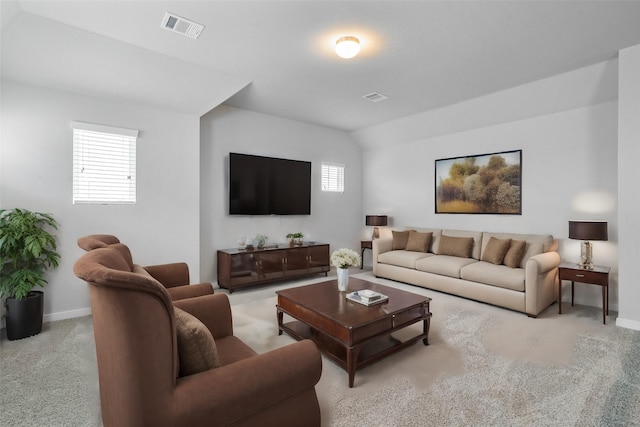 carpeted living area featuring visible vents, lofted ceiling, and baseboards