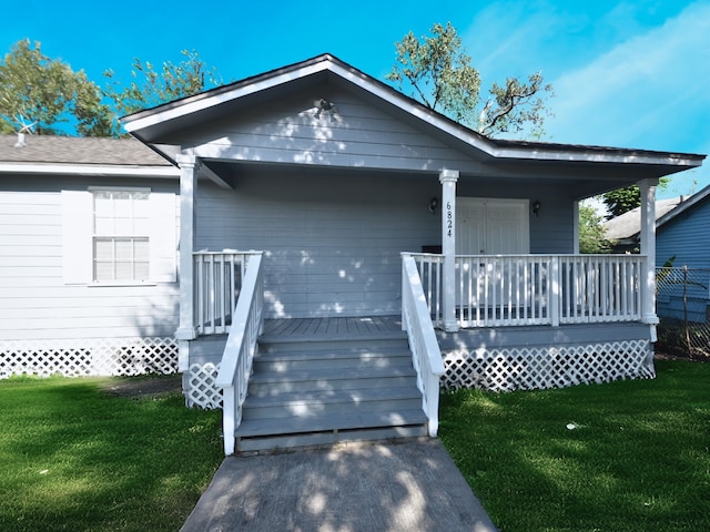 view of front of home with a front yard and a deck