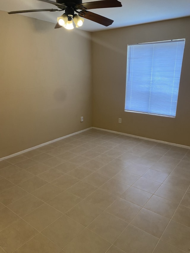 spare room featuring light tile patterned floors and ceiling fan