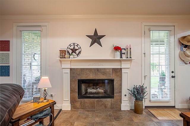 living room with crown molding, a tiled fireplace, and dark hardwood / wood-style floors