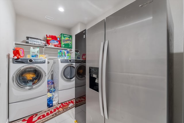 laundry room with washing machine and clothes dryer and light tile patterned flooring