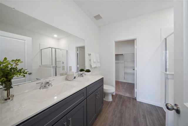 bathroom featuring vanity, toilet, hardwood / wood-style flooring, and a shower with shower door