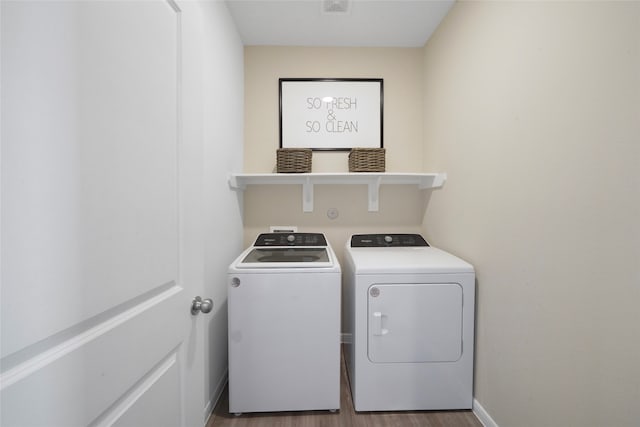 laundry area featuring washer and clothes dryer and hardwood / wood-style floors