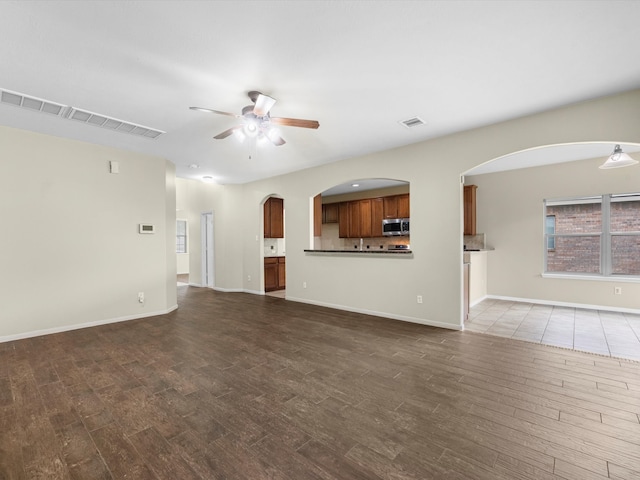 unfurnished living room featuring ceiling fan and wood-type flooring