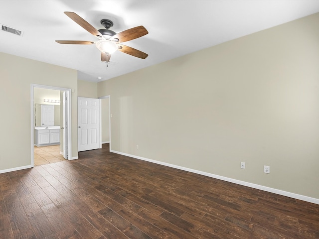 unfurnished bedroom with ceiling fan, ensuite bathroom, and dark hardwood / wood-style floors