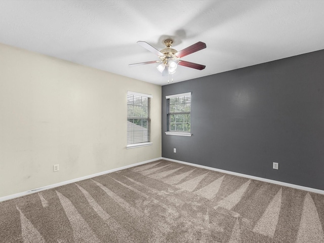 carpeted spare room with ceiling fan