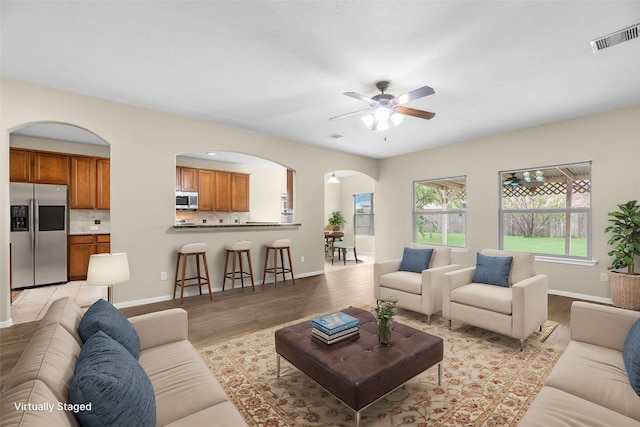 living room featuring light hardwood / wood-style floors and ceiling fan