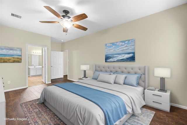 bedroom featuring dark hardwood / wood-style floors, ceiling fan, and connected bathroom