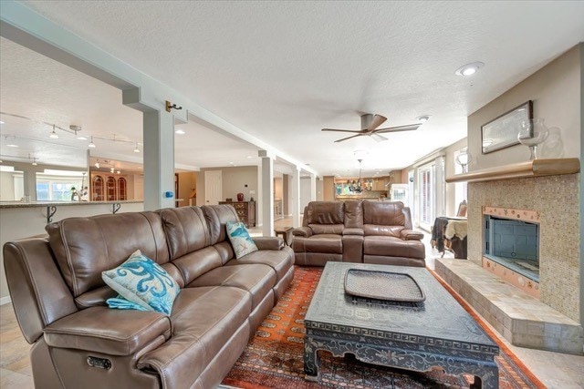 living room with ceiling fan and a textured ceiling