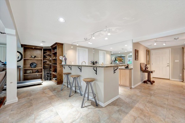 kitchen featuring a breakfast bar, kitchen peninsula, and track lighting