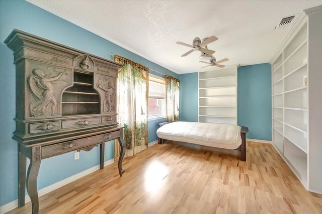 bedroom featuring ceiling fan, light hardwood / wood-style flooring, and a textured ceiling