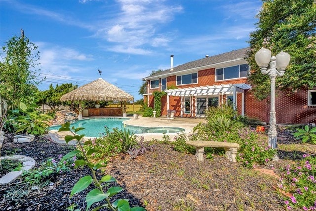 back of house featuring a pergola, a patio, and a pool with hot tub