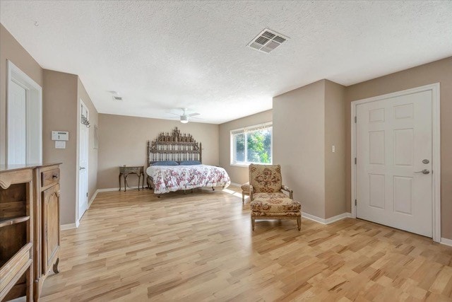 bedroom featuring a textured ceiling and light hardwood / wood-style flooring