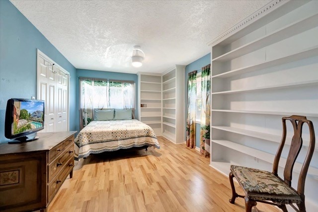 bedroom with a textured ceiling and light hardwood / wood-style floors