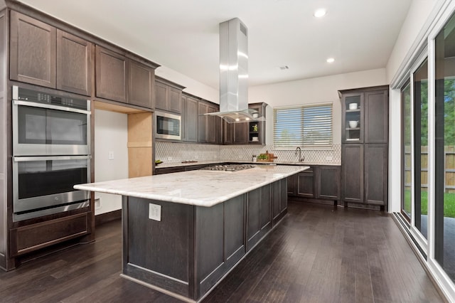 kitchen featuring plenty of natural light, stainless steel appliances, and island exhaust hood