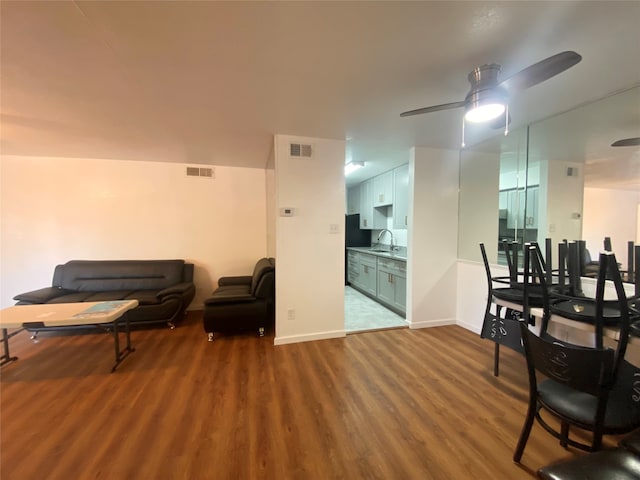 living area with ceiling fan, sink, and hardwood / wood-style flooring