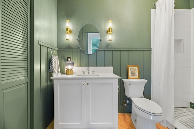 bathroom with wood-type flooring, vanity, walk in shower, and toilet