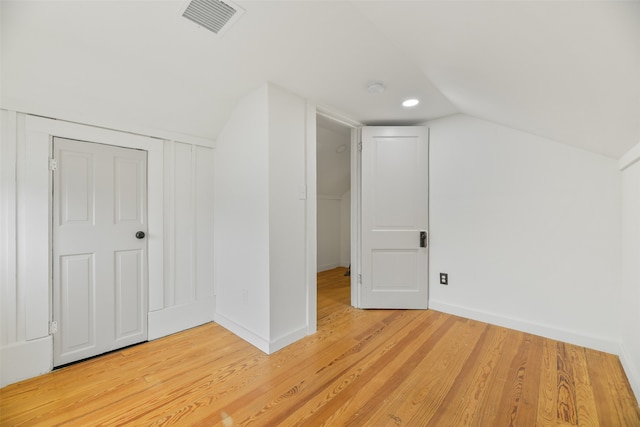 bonus room featuring light wood-type flooring and vaulted ceiling