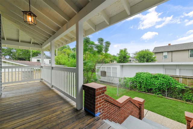 wooden deck featuring a lawn