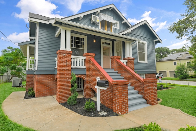 view of front of house featuring central AC unit, a front yard, and a porch