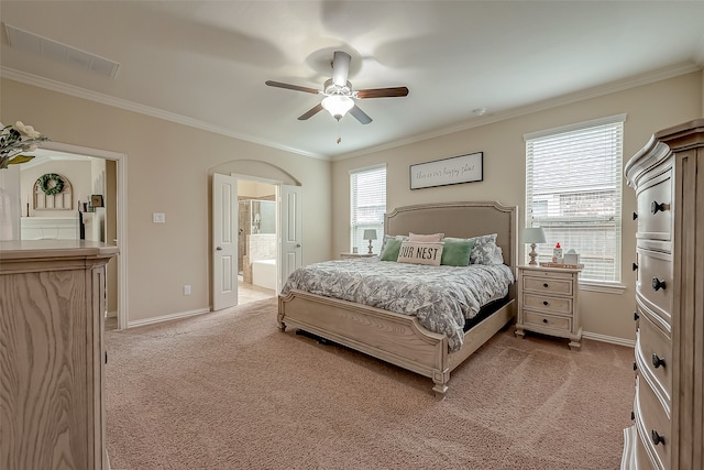 bedroom with ceiling fan, crown molding, light carpet, and connected bathroom