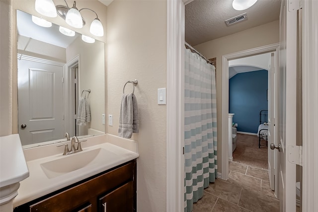 bathroom with tile patterned floors, vanity, and a textured ceiling