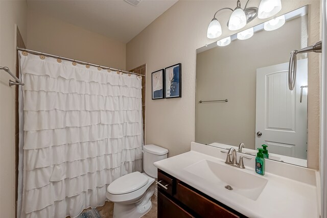 bathroom with curtained shower, vanity, and toilet