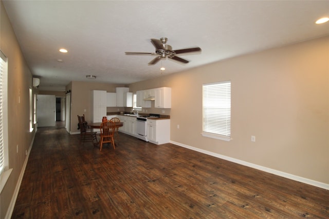 kitchen with white gas range oven, dark hardwood / wood-style flooring, sink, ceiling fan, and white cabinets