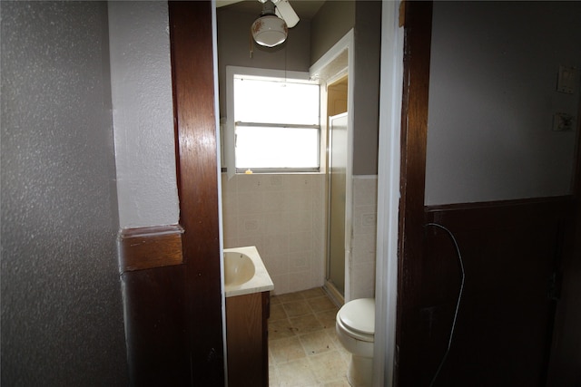 bathroom with toilet, tile patterned flooring, vanity, ceiling fan, and a shower with shower door