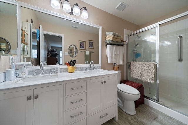 bathroom featuring a shower with door, vanity, toilet, and hardwood / wood-style floors