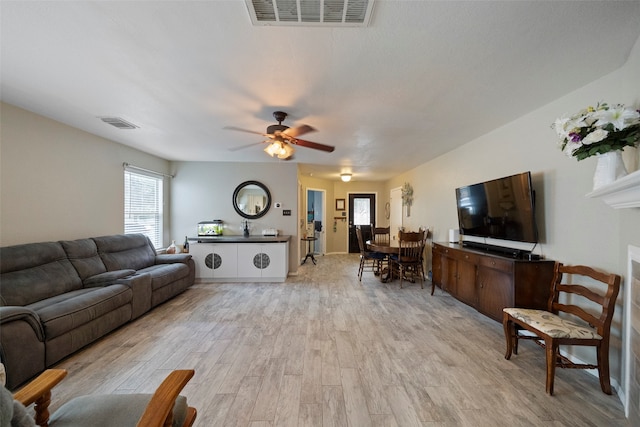 living room with light hardwood / wood-style flooring and ceiling fan