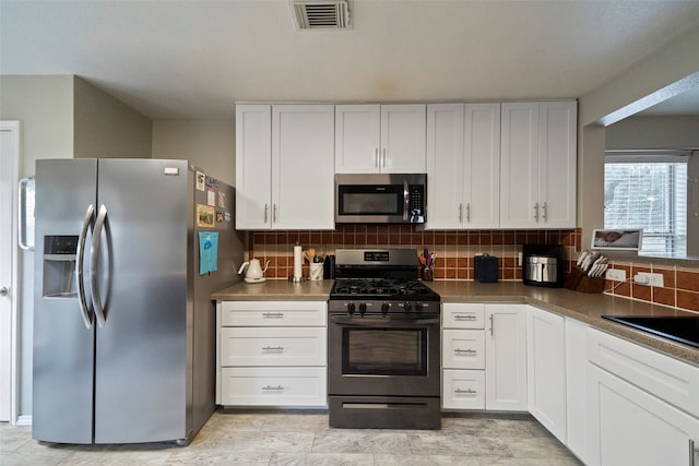 kitchen featuring white cabinets, appliances with stainless steel finishes, backsplash, and sink