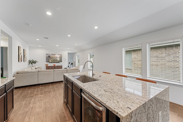 kitchen with an island with sink, plenty of natural light, sink, and light hardwood / wood-style floors