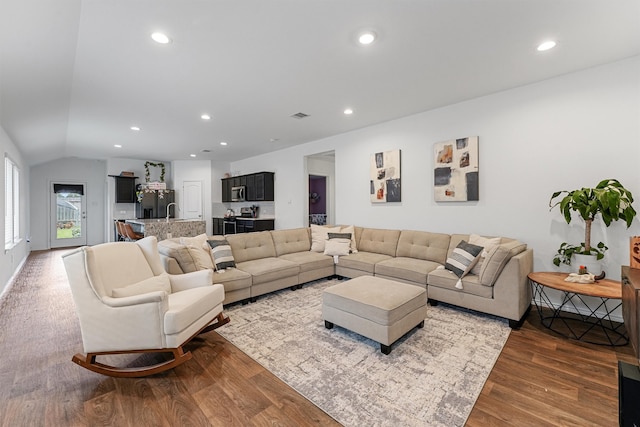 living room featuring lofted ceiling and hardwood / wood-style flooring