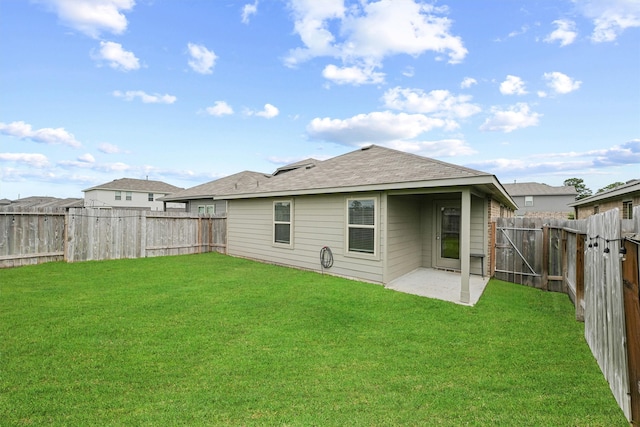 rear view of house with a yard and a patio