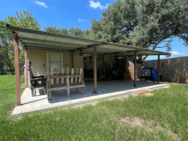 8860 S State Highway 71, El Campo, TX 77437 - back of house with a lawn, fence, a ceiling fan, and a patio area