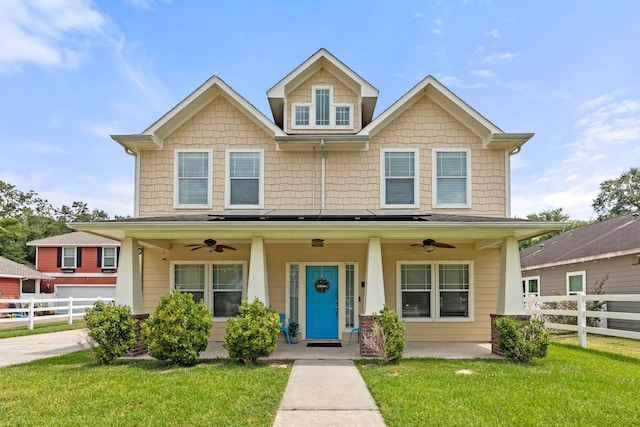 view of front of home featuring ceiling fan, covered porch, and a front lawn