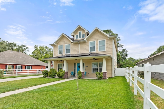 craftsman-style home featuring ceiling fan, covered porch, and a front lawn