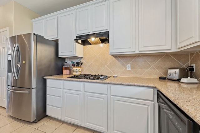 kitchen featuring white cabinets, light stone counters, stainless steel appliances, and light tile patterned flooring