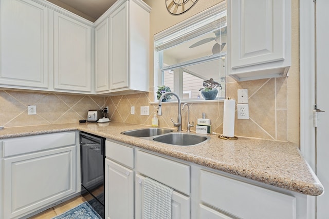 kitchen with dishwasher, light stone counters, sink, decorative backsplash, and white cabinets