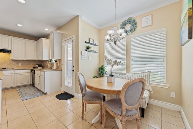 dining area featuring crown molding, light tile patterned floors, plenty of natural light, and a chandelier