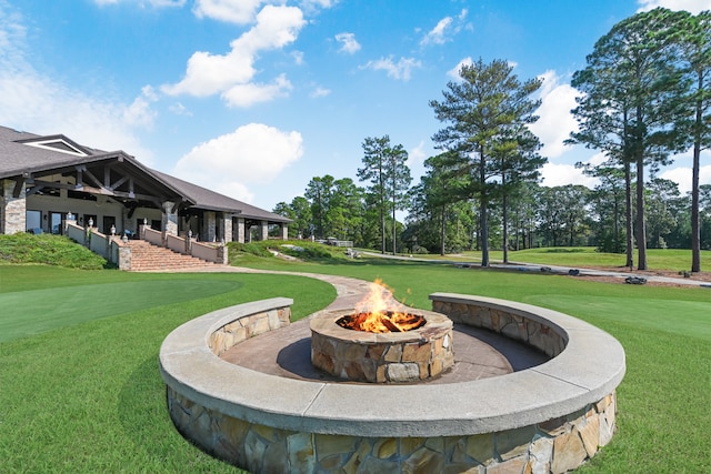 view of property's community featuring a fire pit and a yard