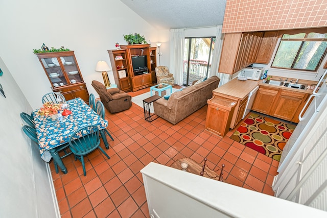 interior space featuring high vaulted ceiling, sink, a textured ceiling, and light tile patterned flooring