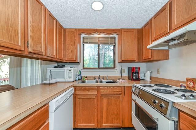 kitchen featuring white appliances, sink, and a textured ceiling