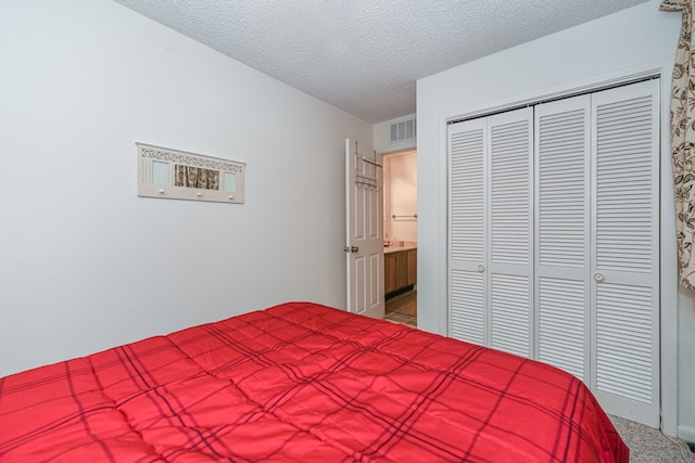 bedroom featuring a textured ceiling, light colored carpet, and a closet