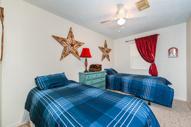 bedroom with ceiling fan, light colored carpet, and a textured ceiling