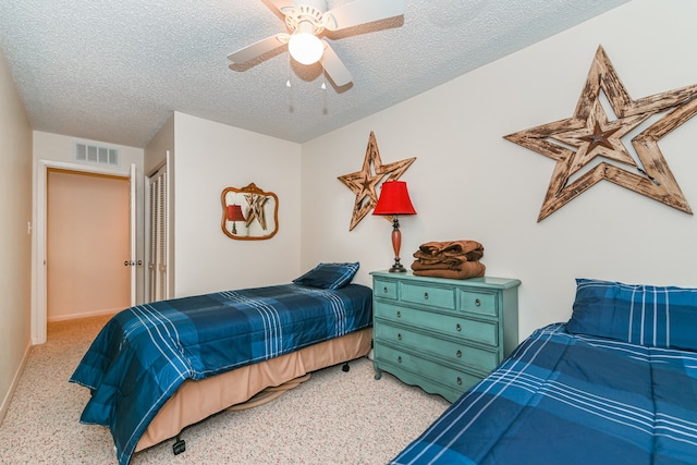 carpeted bedroom featuring a textured ceiling, ceiling fan, and a closet