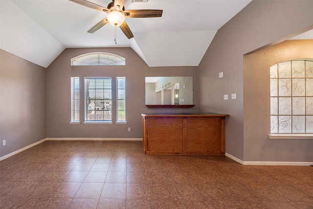 interior space featuring tile patterned flooring, ceiling fan, plenty of natural light, and vaulted ceiling