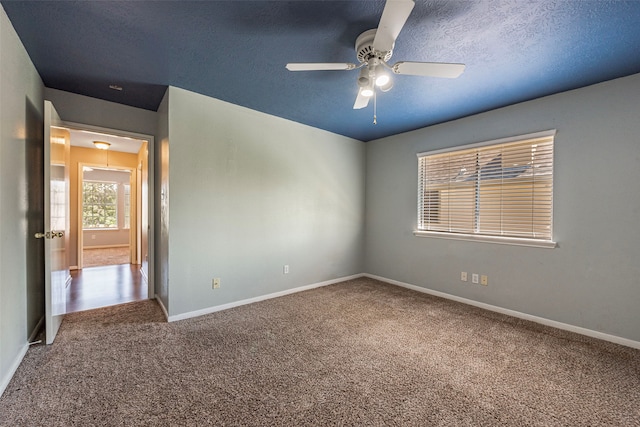 unfurnished room featuring a textured ceiling, ceiling fan, and carpet floors