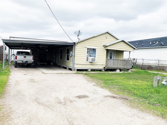 view of front facade with a front yard, a carport, and cooling unit